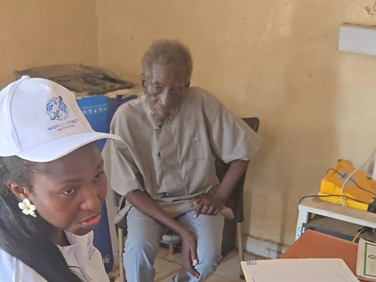 A World Impact Initiative team member speaking with an elderly beneficiary during a needs assessment