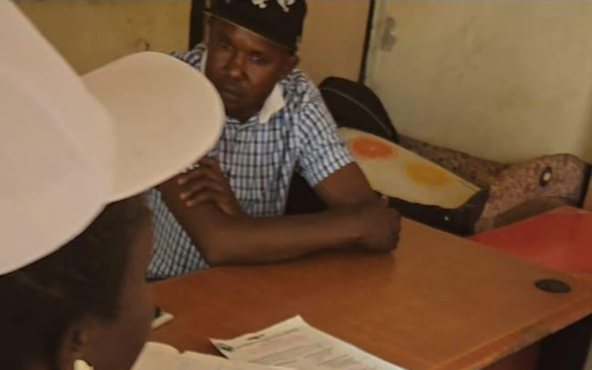 Community members registering with field staff at a beneficiary intake desk