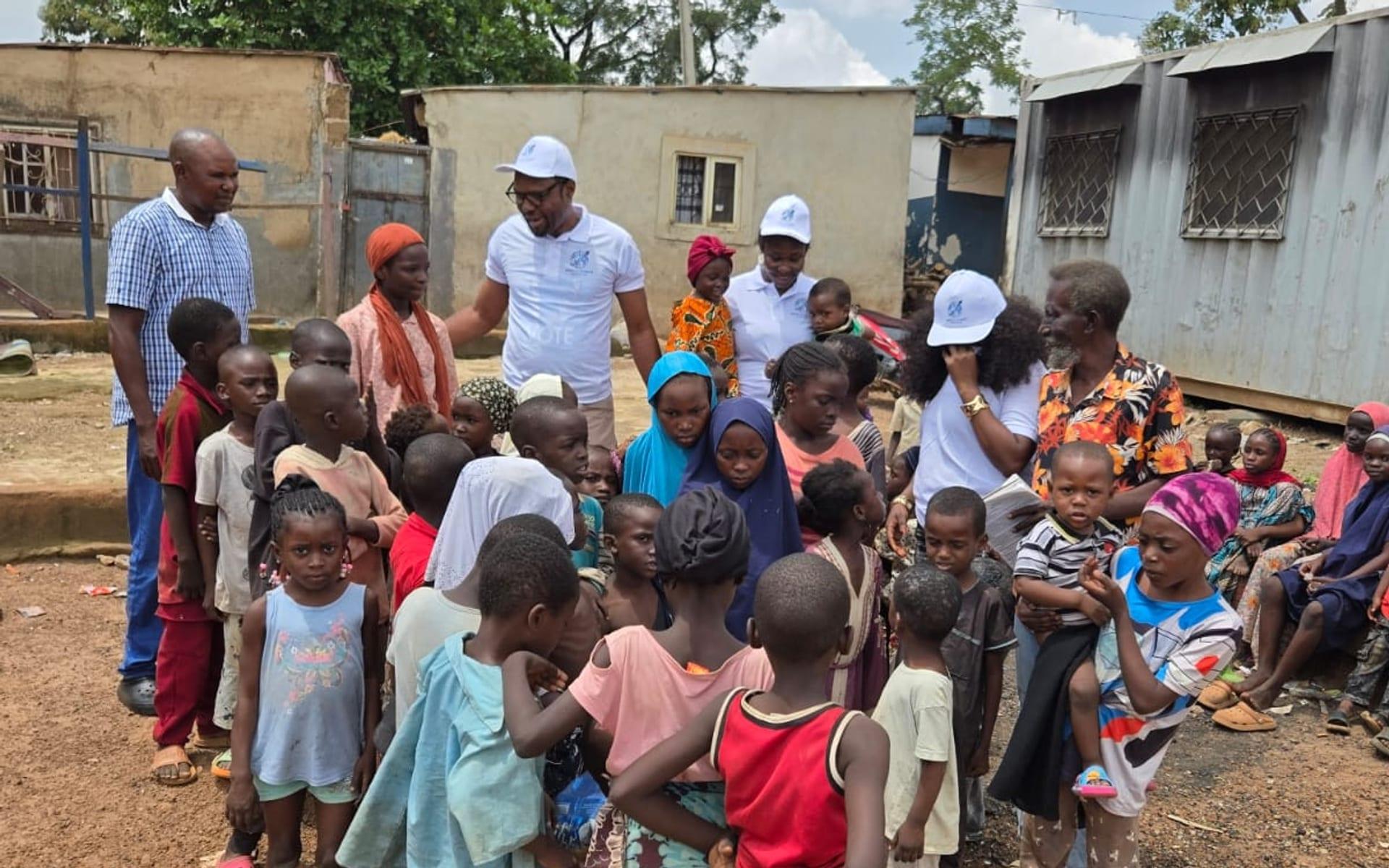 World Impact Initiative staff meeting a crowd of children during a community outreach visit